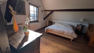 a bedroom with a bed and a vase on a table at Les Perles du Ried - Gîte 202 in Boofzheim