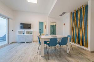 a dining room with a white table and blue chairs at Fichi d'India Appartamenti in San Pietro in Bevagna +11 photos