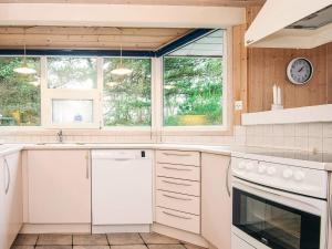 eine Küche mit weißen Geräten und 2 Fenstern in der Unterkunft Secluded Retreat by Lyngbo Heath - By Traum Ferienwohnungen in Henne Strand + 49 Fotos