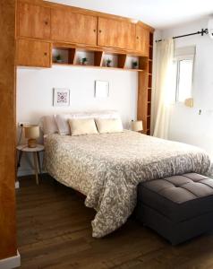 Un dormitorio con una cama y armarios de madera. en Casa Chica, en Málaga 19 fotos más