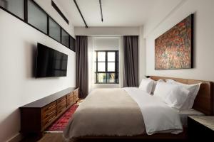 a bedroom with a large bed and a tv at Centrale Lustica Bay by Angsana in Radovići