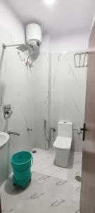 Un baño con inodoro y un cubo verde. en Hotel Relax, en Jaipur