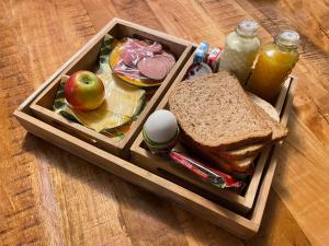 una bandeja de madera con una lonchera que contiene un sándwich y manzanas en BnB Goldies II, en Eindhoven