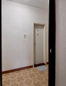 an empty room with a hallway with a door at Small Hill Guesthouse in Podgorica