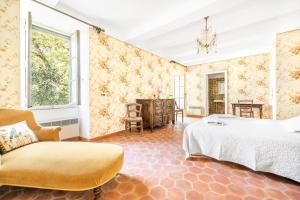 a bedroom with a bed and a chair at Mas de Thésée Piscine & 12 ha privés in Reillanne