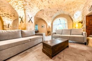 a living room with a couch and a table at Mas de Thésée Piscine & 12 ha privés in Reillanne