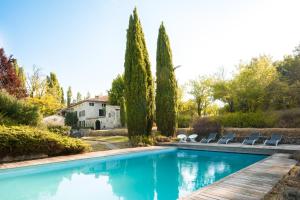 a swimming pool in a garden with trees and chairs at Mas de Thésée Piscine & 12 ha privés in Reillanne