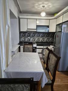 eine Küche mit Tisch und Stühlen und einem Kühlschrank in der Unterkunft Tsese in Ulaanbaatar