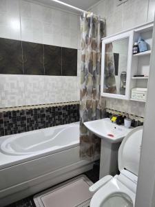ein Badezimmer mit Badewanne, Toilette und Waschbecken in der Unterkunft Tsese in Ulaanbaatar