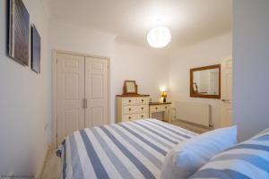 a bedroom with a bed and a dresser and a mirror at Stones Throw in Woolacombe