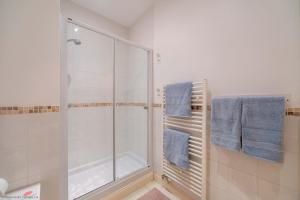 a bathroom with a shower and blue towels at Stones Throw in Woolacombe +5 photos