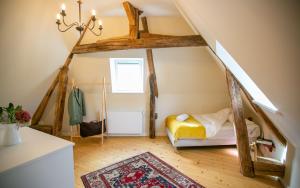 Una habitación abuhardillada con una cama y una escalera. en Aux Roses et aux Poutres, en Le Tremblay-le-Vicomte