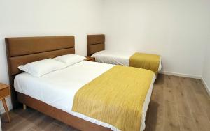 2 Betten in einem kleinen Zimmer mit weißen Wänden in der Unterkunft Casa João de Quintal in Elvas