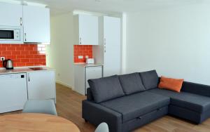 ein Wohnzimmer mit Sofa und eine Küche in der Unterkunft Casa João de Quintal in Elvas