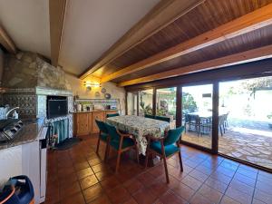 Un comedor con mesa y sillas y una cocina. en Entrefrutales, en La Vilueña