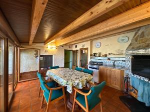 Un comedor con mesa y sillas y una cocina. en Entrefrutales, en La Vilueña