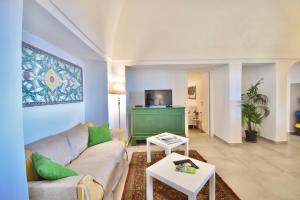a living room with a couch and a tv at Dammusi Sciuvechi in Pantelleria