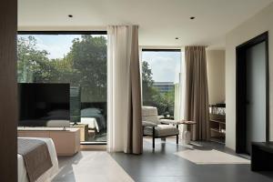 sala de estar con TV y ventana grande en Guilin Lakeview Boutique Lodge, en Guilin