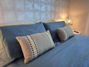 a blue bed with three pillows on it at Casa Abetos in Collado Mediano