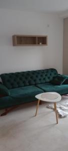 een groene bank in een woonkamer met een tafel bij Apartmant Novaković in Vrnjačka Banja +11 foto's