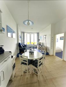 a kitchen and living room with a table and chairs at Se 06 Haus Seeterrassen in Cuxhaven +10 photos