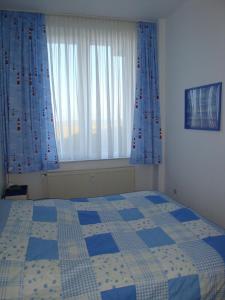 a bedroom with a bed and two large windows at Se 06 Haus Seeterrassen in Cuxhaven