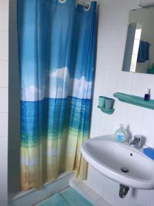 a bathroom with a shower curtain and a sink at Se 06 Haus Seeterrassen in Cuxhaven
