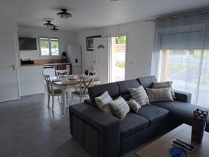 a living room with a blue couch and a table at Kerhuella in Saint-Ségal