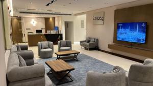 a waiting room with chairs and a flat screen tv at اجنحة دانة DANAT Suites الرياض حي اليرموك in Riyadh