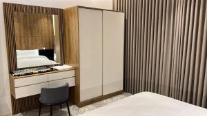 a bedroom with a mirror and a bed and a chair at اجنحة دانة DANAT Suites الرياض حي اليرموك in Riyadh