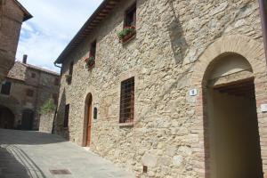 a stone building with flower boxes on the side of it at Alla Porta di Sopra in Castiglione dʼOrcia
