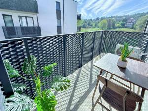 ジヴィエツにあるWierzbowa 13 Apartament - blisko jeziora i ścieżek rowerowychのバルコニー(テーブル、植物付)