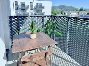 ジヴィエツにあるWierzbowa 13 Apartament - blisko jeziora i ścieżek rowerowychのバルコニーに木製のテーブルと椅子2脚