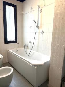 ein weißes Badezimmer mit Badewanne und Toilette in der Unterkunft LAERTE PALACE HOTEL in Mogliano Veneto + 40 Fotos