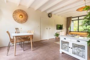 Una cocina y un comedor con mesa y sillas. en Bungalow Veldzicht | 4 personen - Vakantiepark De Kremmer, en Gasselte