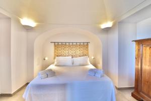 a bedroom with a large white bed with two pillows at Dammusi Sciuvechi in Pantelleria +115 photos