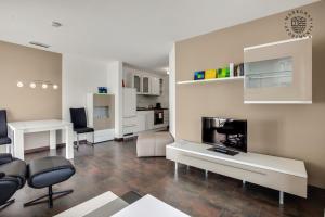 a large living room with white furniture and a kitchen at ! NEU ! Markgraf Premium Apartments - Bad Bellingen in Bad Bellingen
