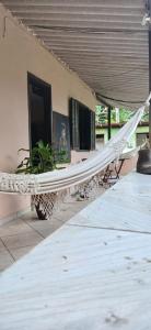 a hammock on the side of a house with a person in a window at SacodoCeu2026 in Angra dos Reis