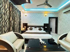 a bedroom with a bed and a couch and a table at Sky Light Inn Hotel in Gurgaon
