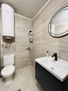 a bathroom with a toilet and a sink and a mirror at IN&P Apartment - top location in Veliko Tŭrnovo