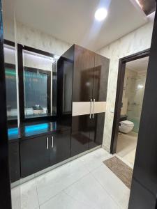 a bathroom with black cabinets and a toilet at Sky Light Inn Hotel in Gurgaon