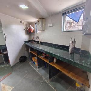 a kitchen with a counter and a sink at Hans Dormitory in Mumbai
