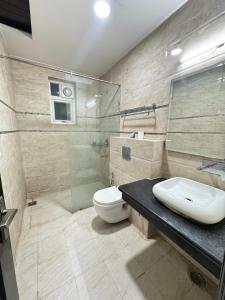 a bathroom with a toilet and a glass shower at Sky Light Inn Hotel in Gurgaon