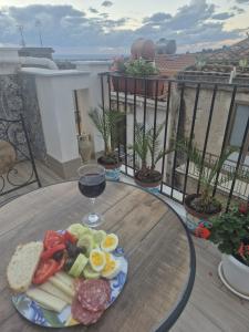a plate of food on a table with a glass of wine at Regina Stella in Lascari