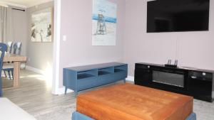 een woonkamer met een tv en een tafel bij Bay Beach Bungalow in Town Bank