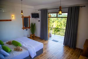 a bedroom with a bed and a large window at Tunnel Top Inn Ella in Ella