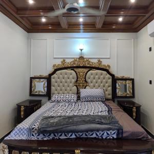 a bedroom with a large bed with a large headboard at AlFalah Guest House in Murree