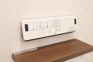 a control panel on a wall above a wooden shelf at FabulousOdawara in Odawara