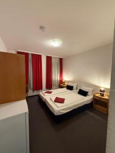 a hotel room with a bed and red curtains at Hotel Nassauer Hof Frankfurt in Frankfurt/Main