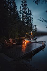 a dock with two chairs and a swing on a lake at Birdbox Tokke 